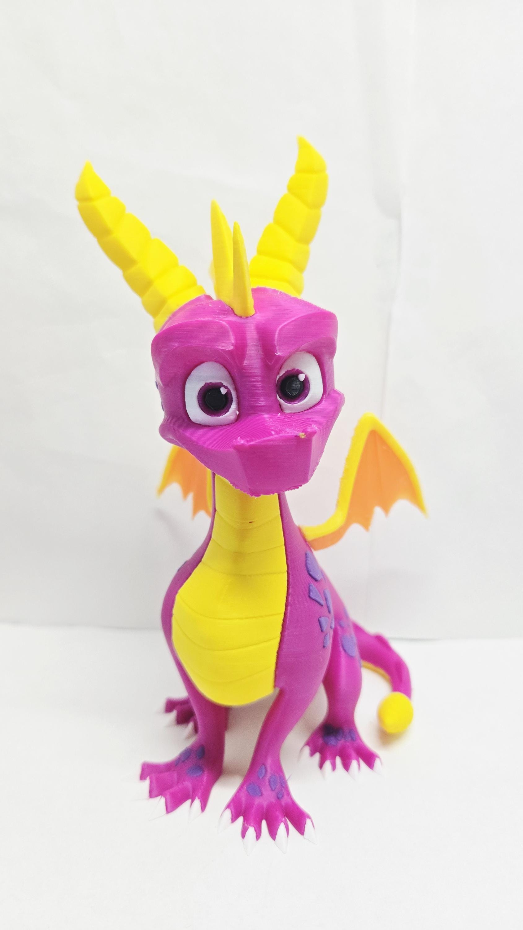 Straight front view of the 3D printed Spyro display figure showing his face, yellow horns, and heroic stance