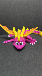 Straight front view of the articulated Spyro flexi figure showing his face, yellow horns, and inquisitive expression