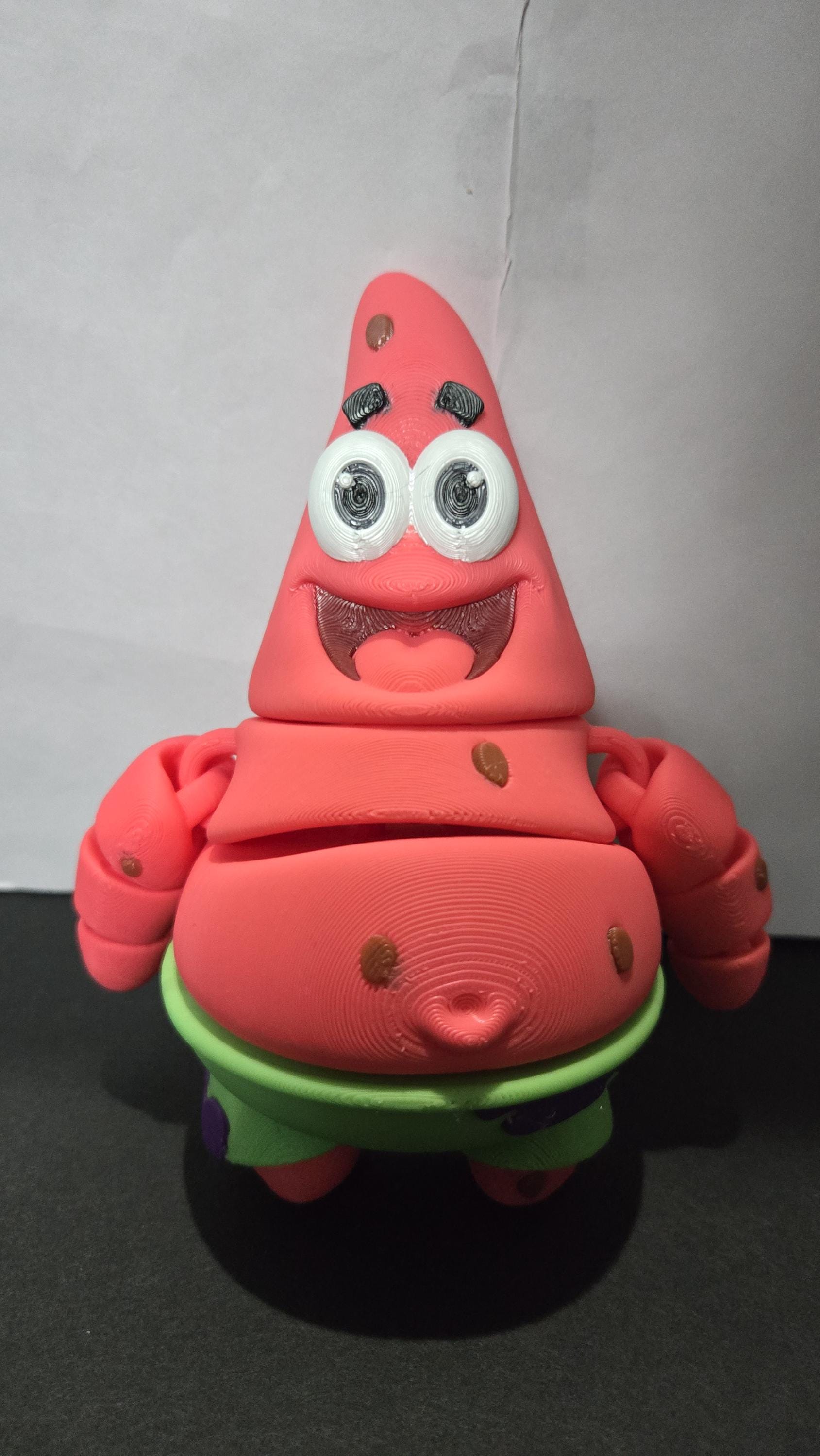 Close-up view of the 3D printed star flexi figure showcasing the vibrant pink and green color detail