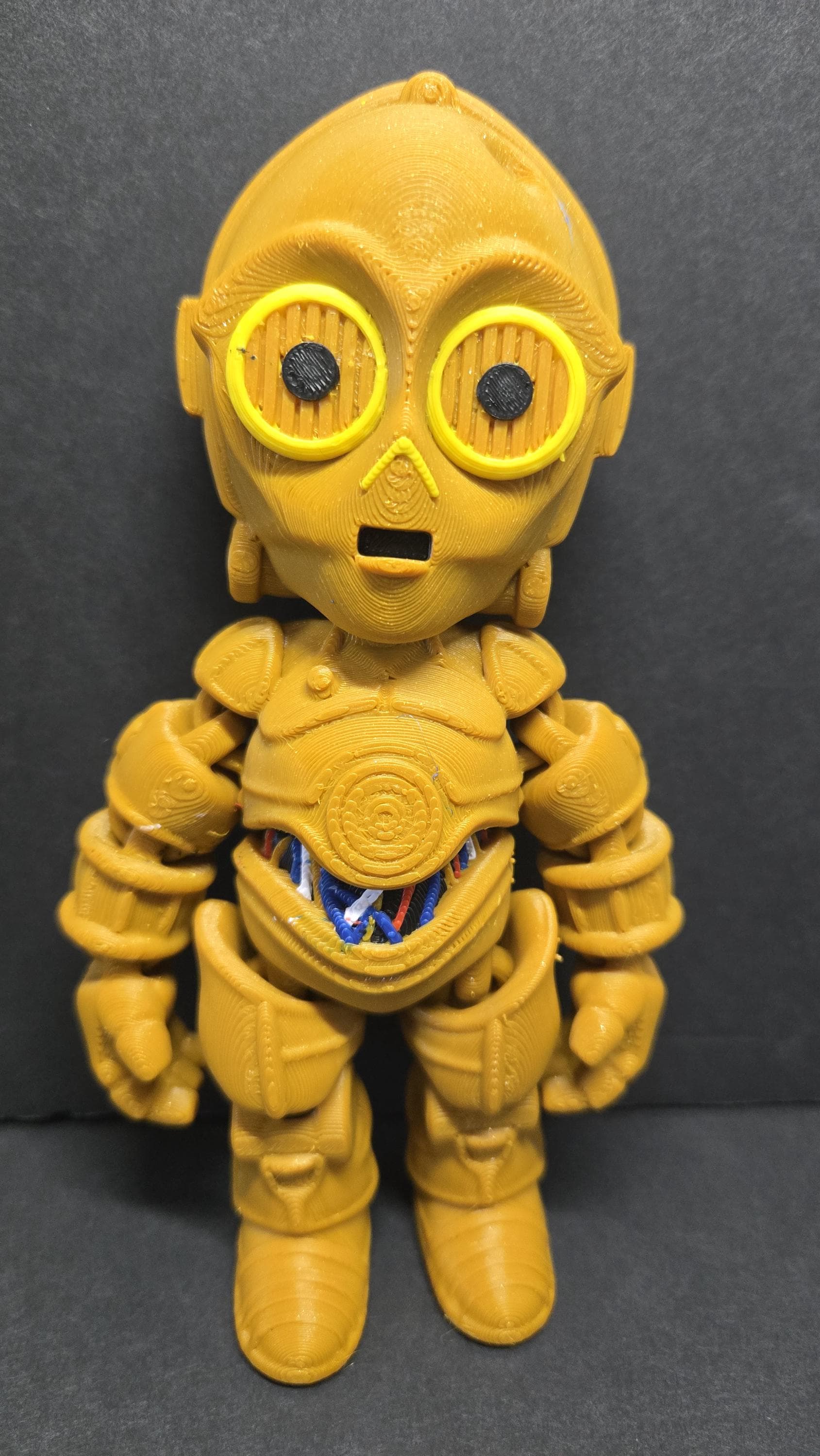 Full-color 3D printed C-3PO flexi figure standing upright on a flat surface showing a complete front view