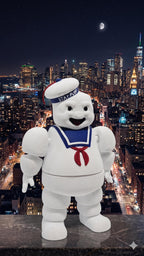 The 3D printed Stay Puft flexi figure displayed standing against a vibrant night-time NYC cityscape background
