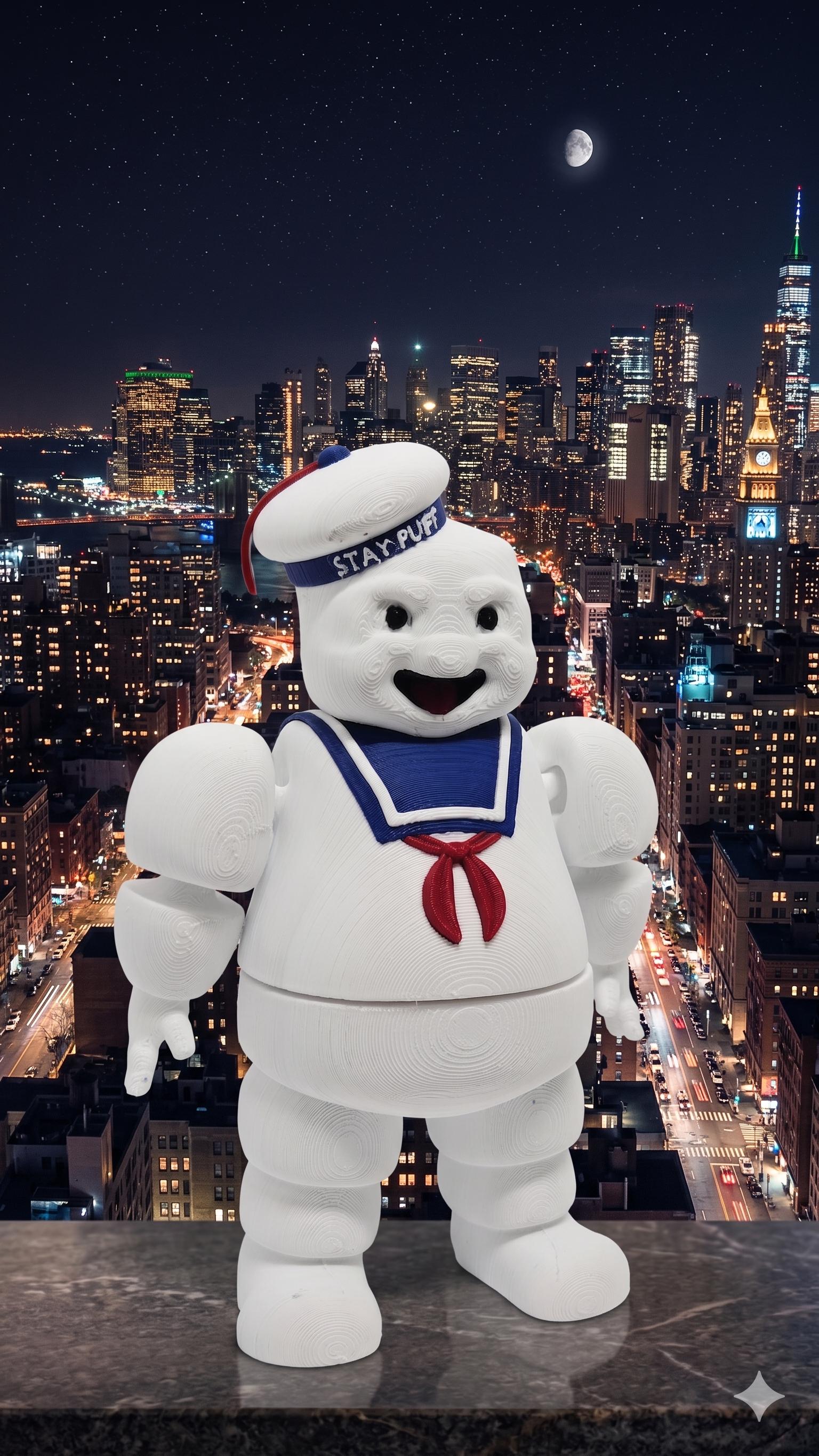 The 3D printed Stay Puft flexi figure displayed standing against a vibrant night-time NYC cityscape background