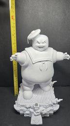 A vertical yellow measuring tape placed alongside the fully assembled Stay Puft diorama to display its exact physical height