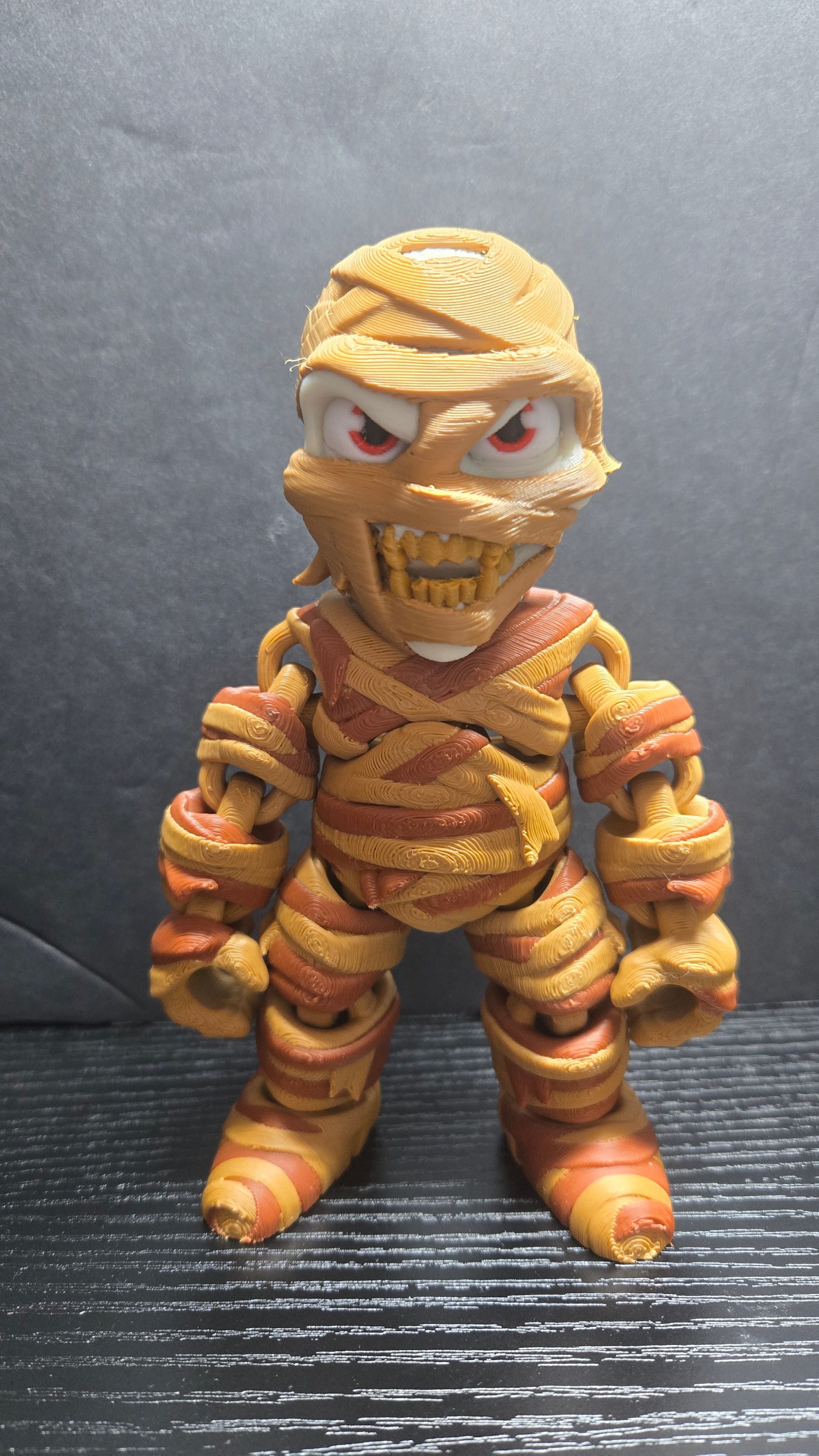 6-inch articulated Mummy flexi figure standing on a dark studio surface showing its wrapped bandages and snarling face