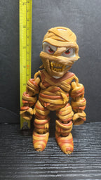 The Mummy flexi figure standing next to a yellow measuring tape to display its 6-inch height