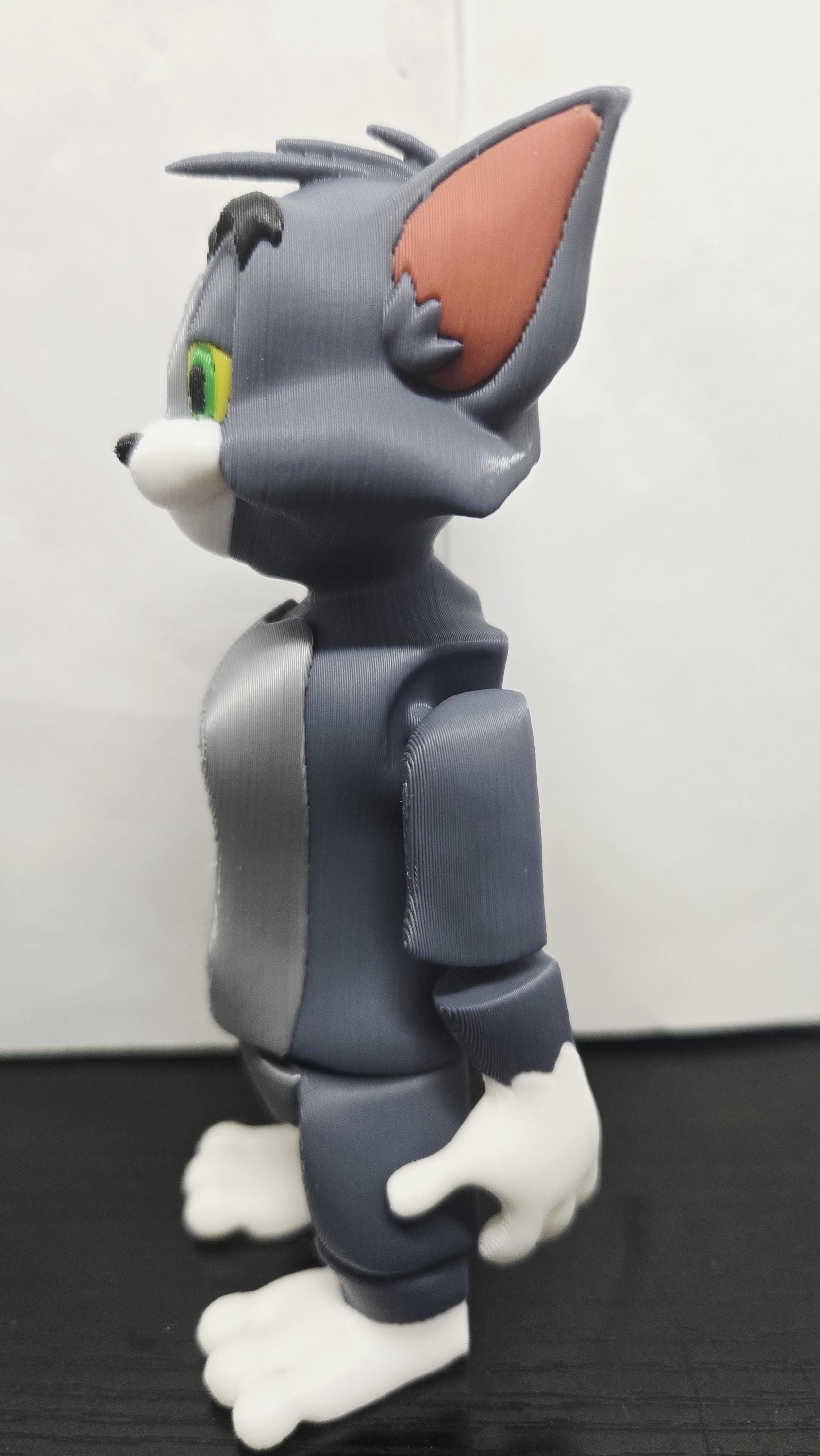 Left side profile view of the flexible Tom Cat figure showing the ear shape, paw detail, and arm articulation joints