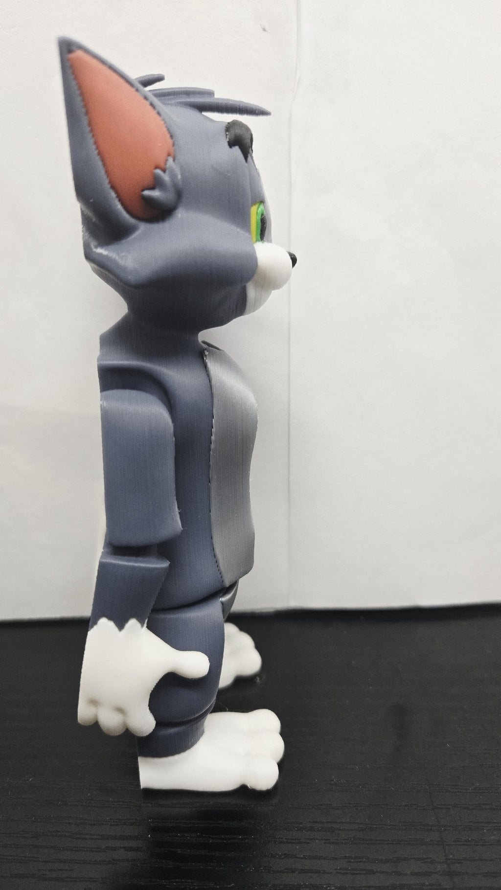 Right side profile view of the flexible Tom Cat figure demonstrating the smooth grey and white multi-color print details
