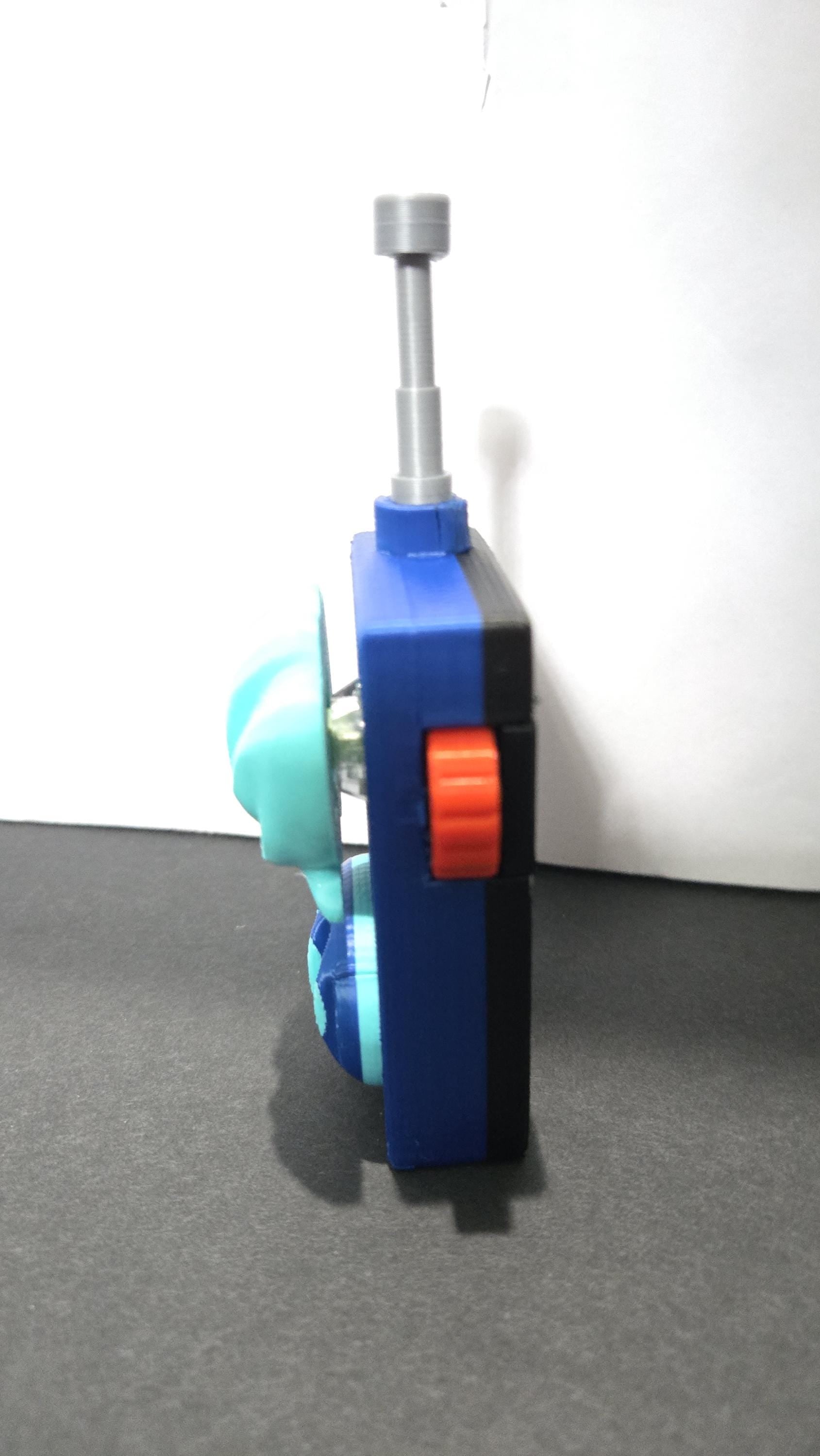Side profile view of the 3D printed walkie-talkie prop highlighting the red trigger button and antenna detail
