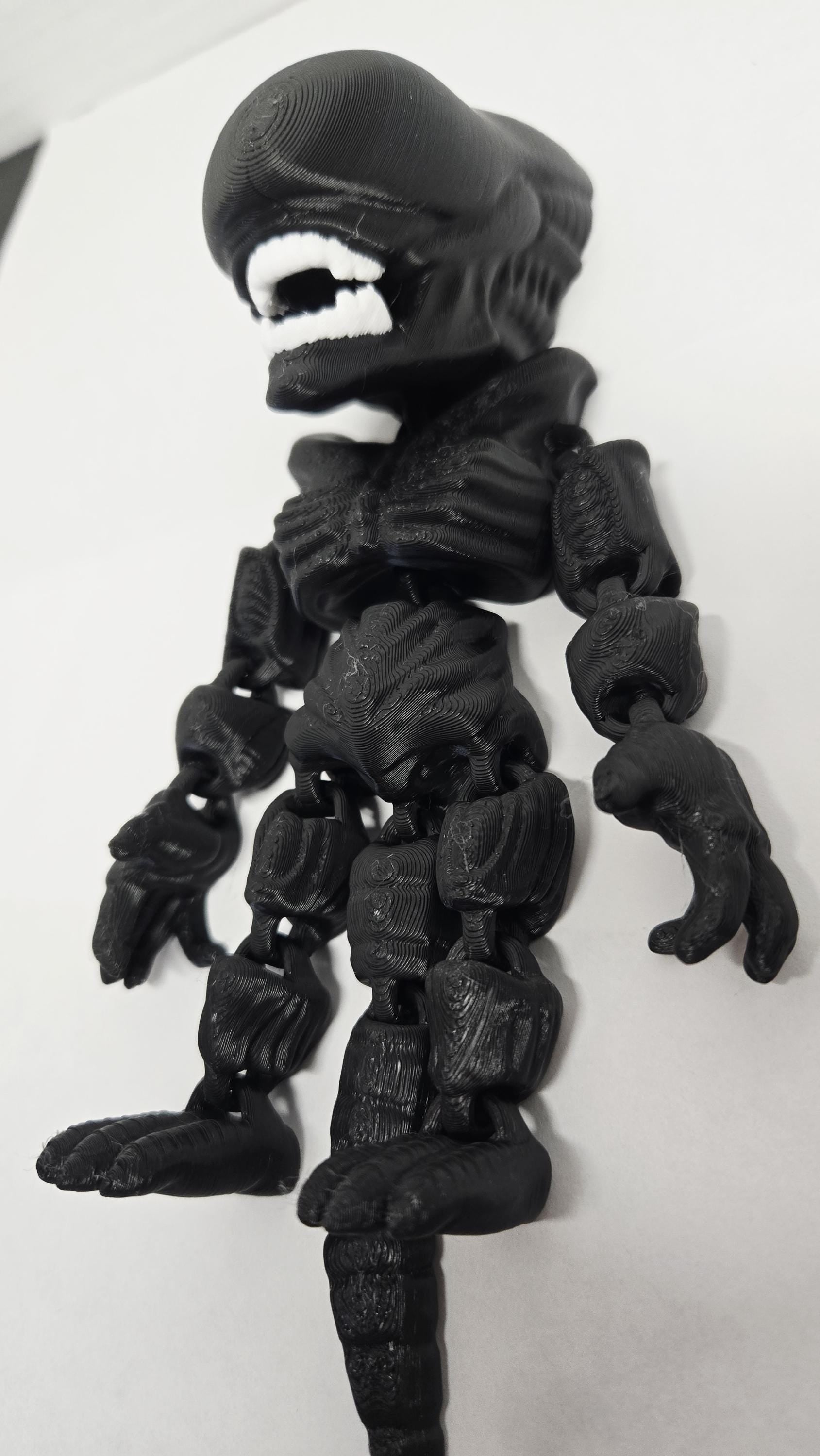 Right side view of the jointed Xenomorph figure slightly flexed to demonstrate the dynamic movement of the tail and leg segments